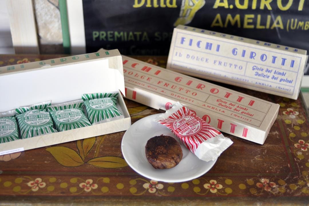 gift boxes and a plate with a famous Girotti fig , wrapper in striped paper in red, green, and white