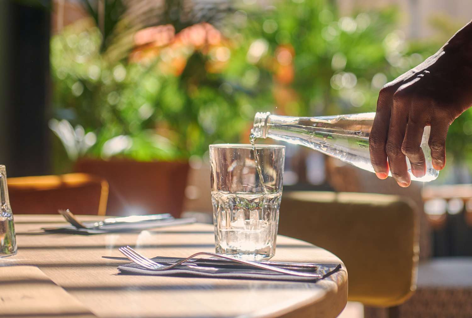 A waiter pours a glass of water in a restaurant
