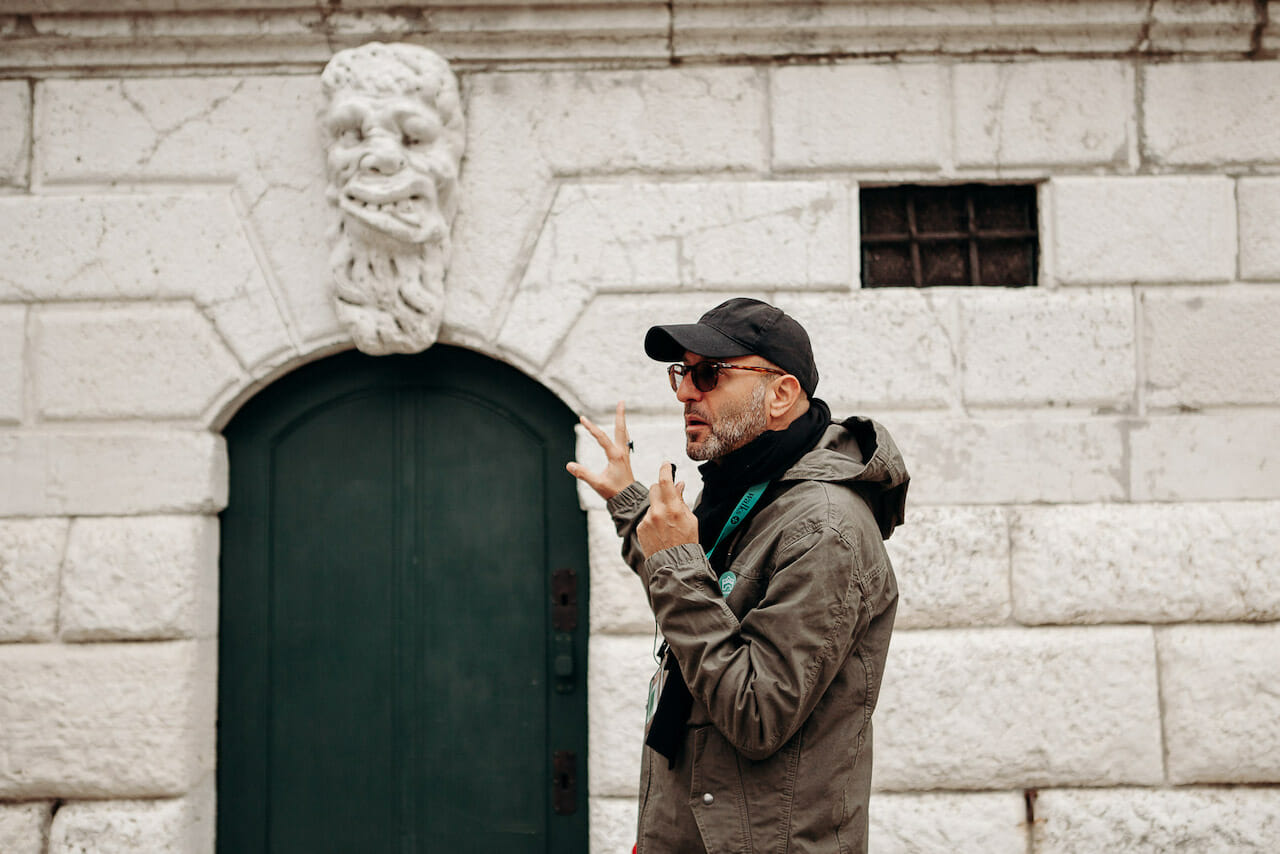 Walks Tour guide explains the meaning of a hidden symbol in Venice during the cooler winter months