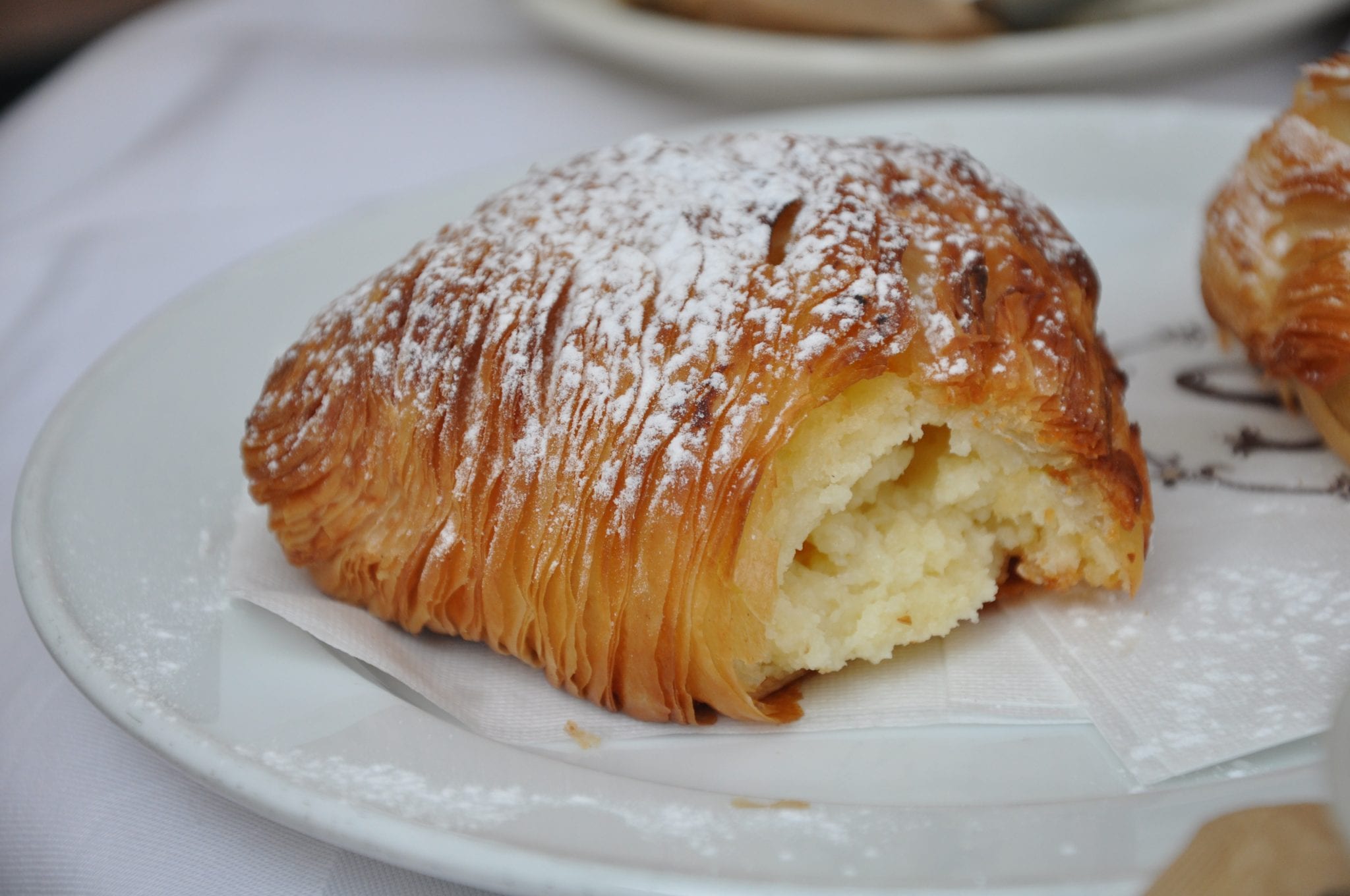 Sfogliatella, a traditional italian desserts, on a plate with powdered sugar