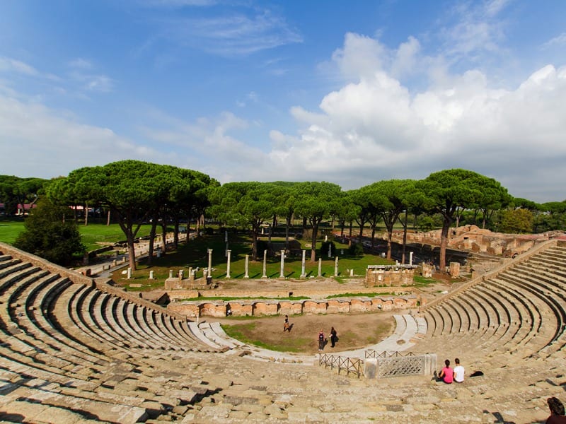 Ostia Antica –the ancient port city of Rome, ruins of an ancient ampitheater with columns and freen trees