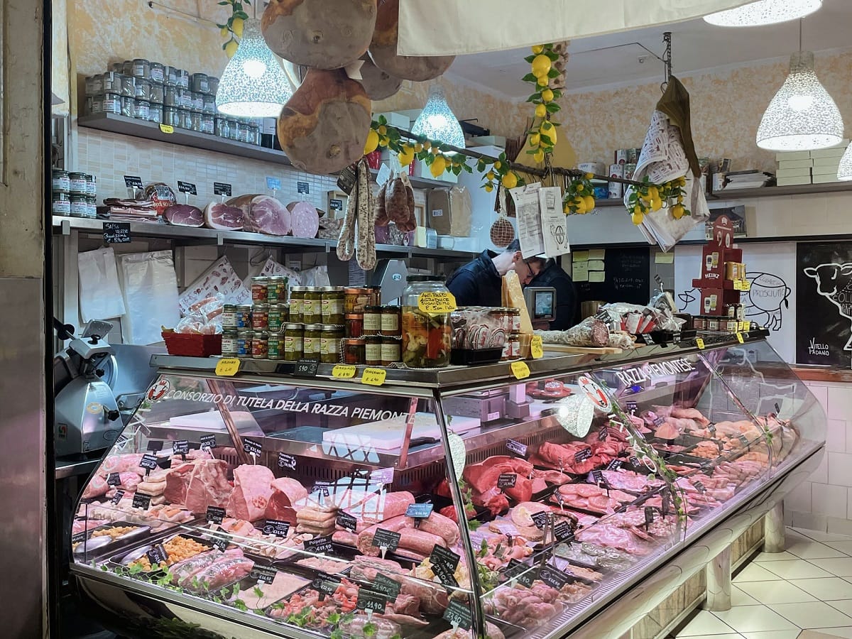 A typical Italian butcher shop with massive glass display of various meats.