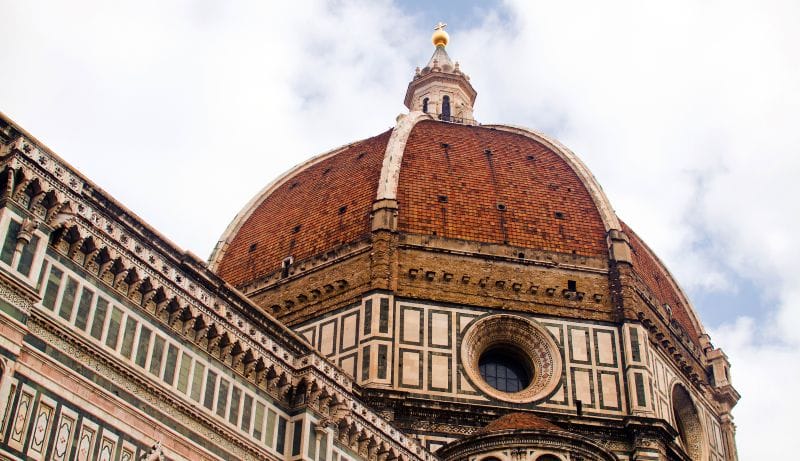 The exterior of Florence's Duomo, with its distinctive red dome and black and white facade.