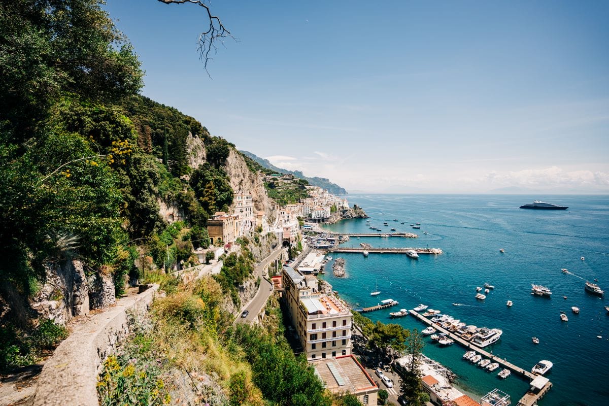 Coastal hiking route on the Amalfi Coast looking over a harbor with several boats in the water.