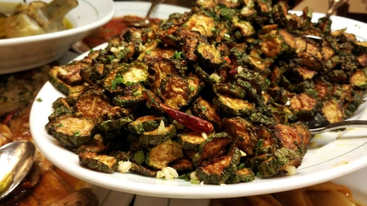 A large plate of concia di zucchine, sauteed zucchini with garlic and mint.