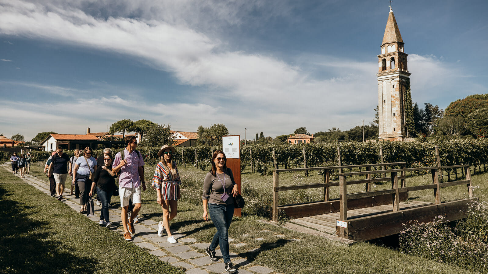 Group of travelers walks through a vineyard in Mazzorbo, Italy.