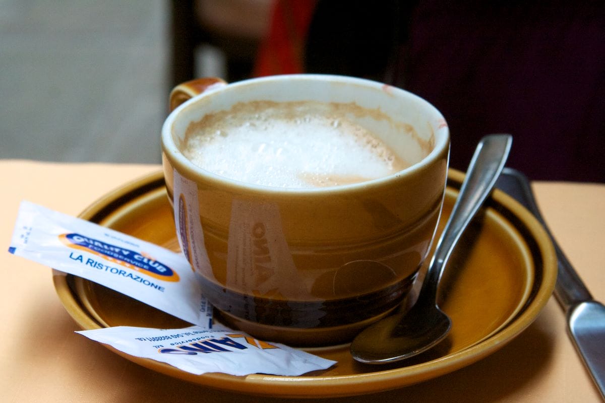 close up of cappuccino with sugar packets on the side in Italy.  