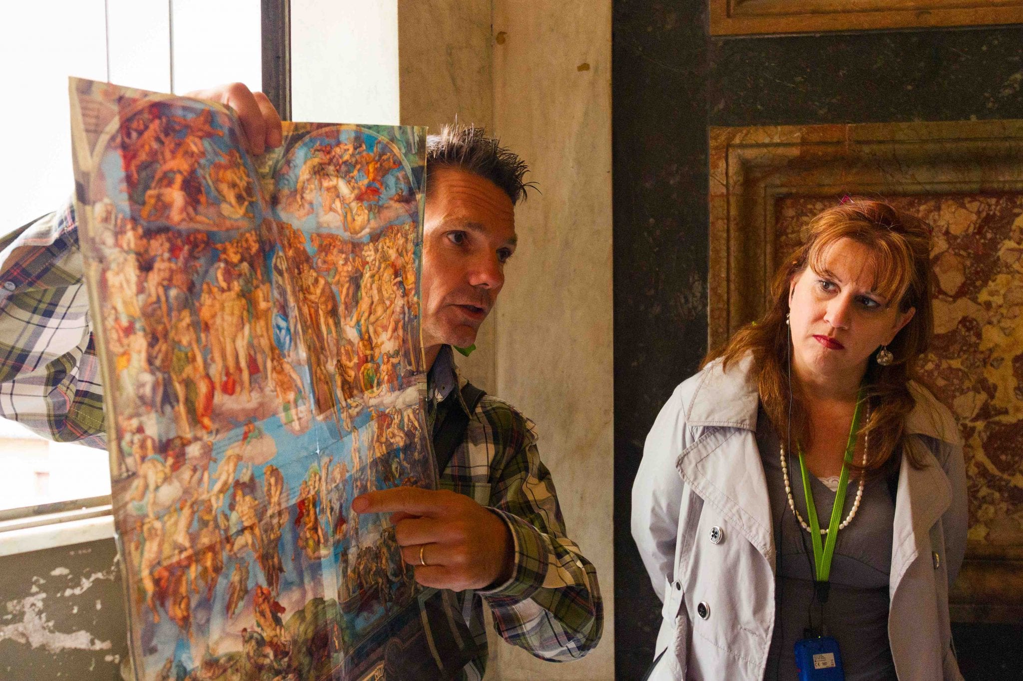 A tour guide points out the ornate drawing to visitors on the tour