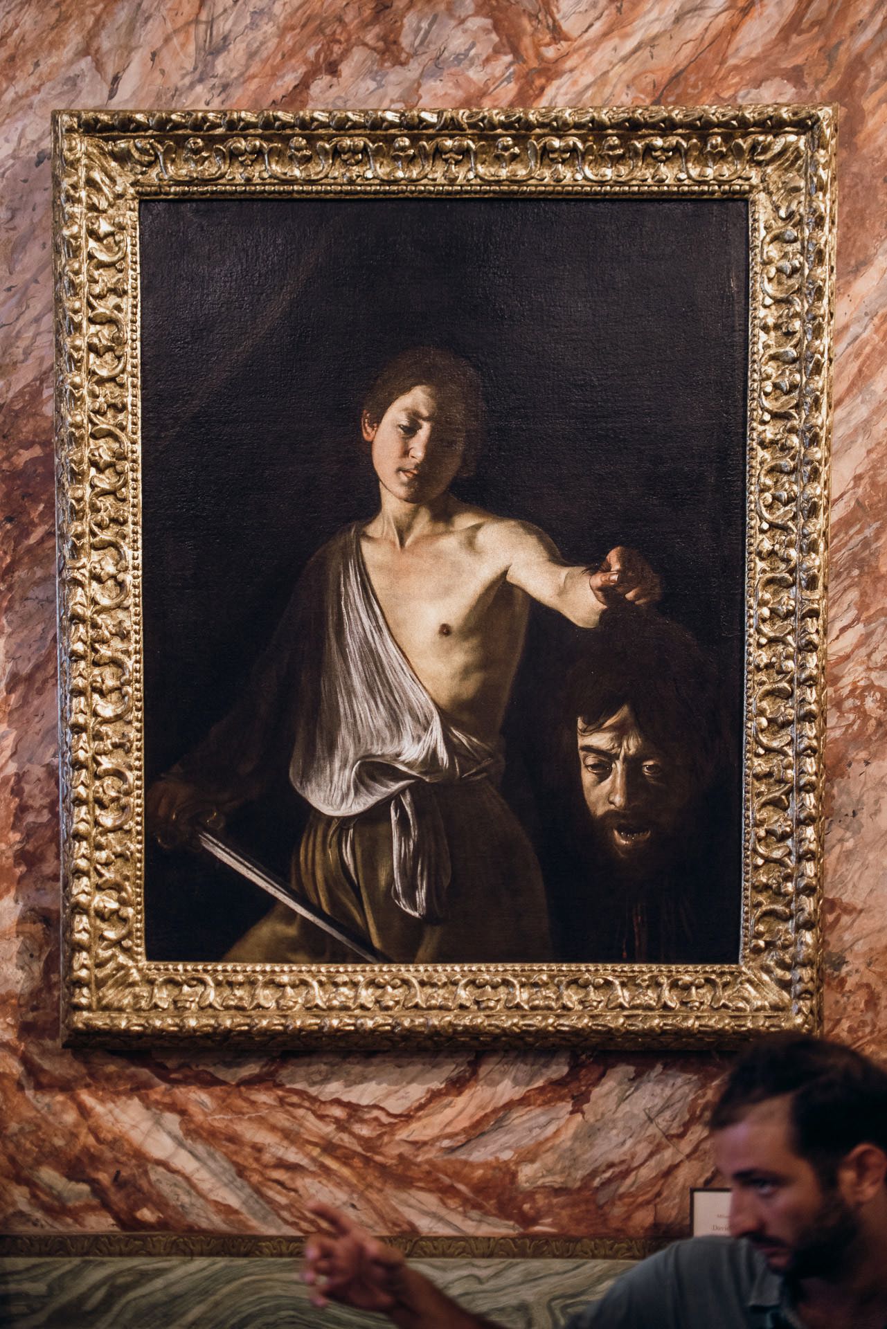 A painting of a man holding a head