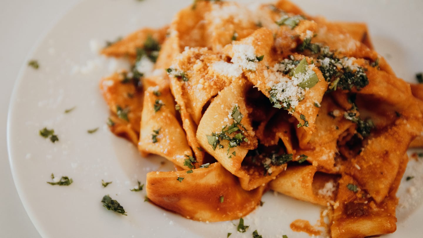 Pasta on a plate with fresh herbs and cheese at one of the best restaurants in Florence.