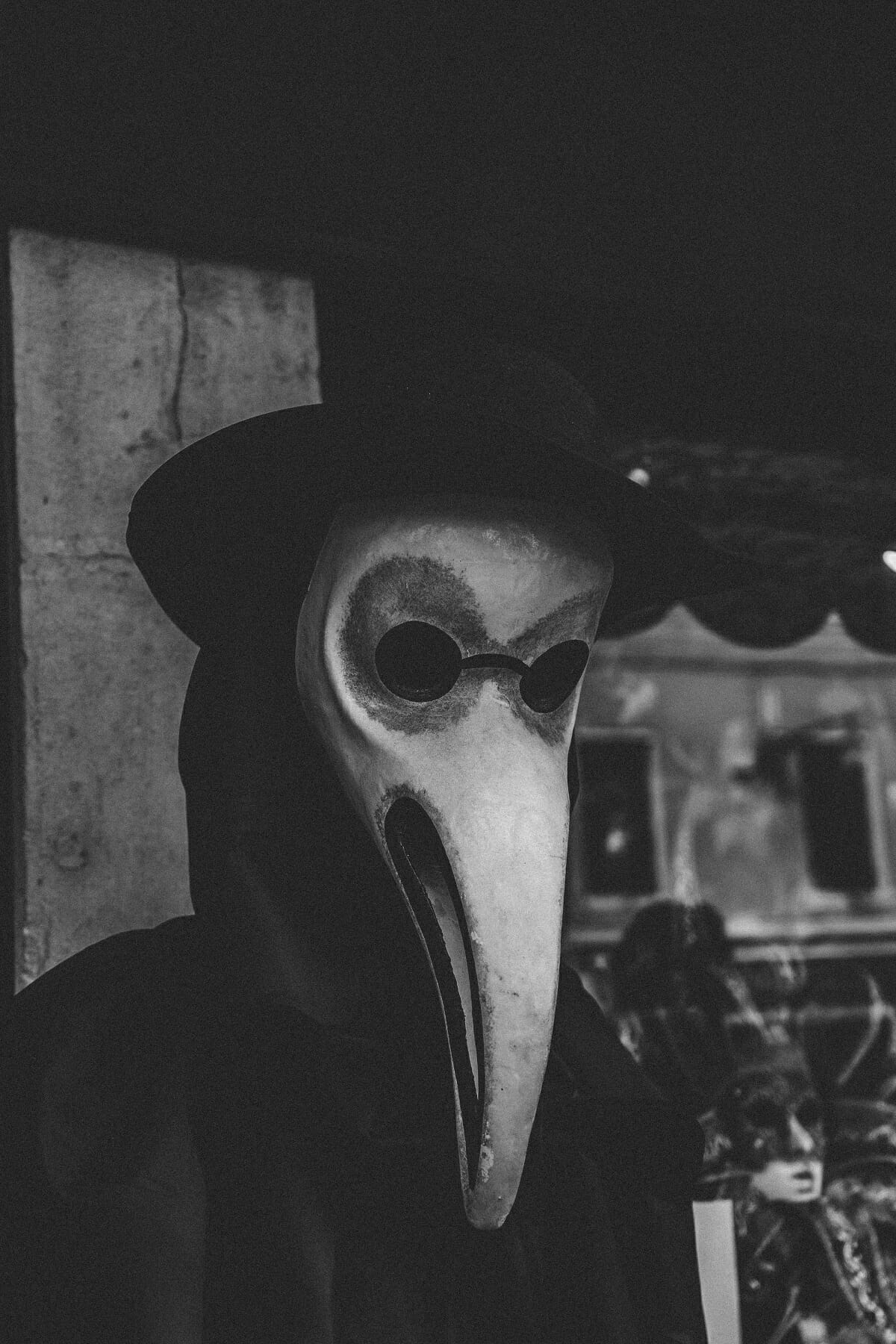 Pereson wearing a Plague Doctor mask with beaked nose.