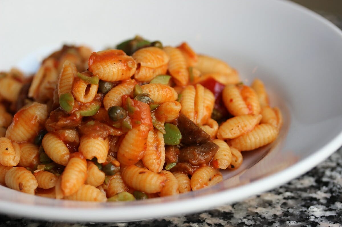 Plate of cavatelli pasta with peas and tomato sauce