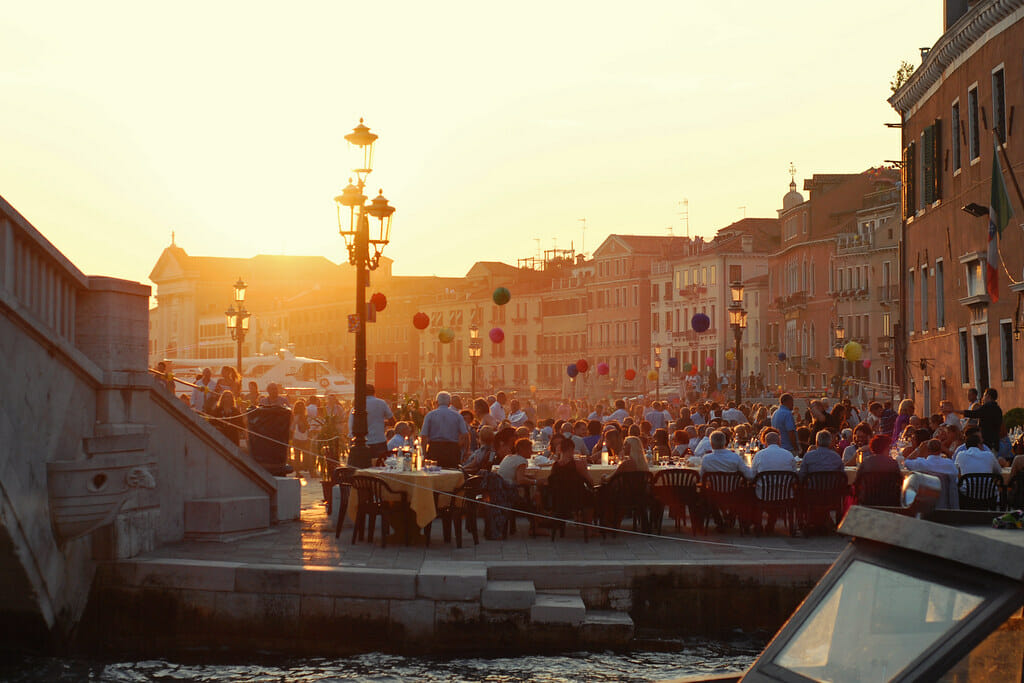 Locals in Venice outside celebrating the Festa del Redentore with balloons, food, and tables