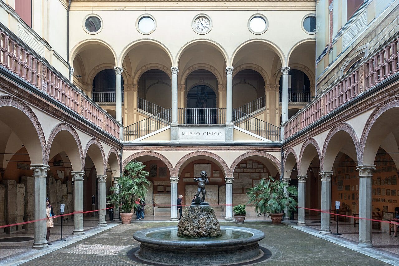 Interior courtyard with fountain, statue, and columns at Bologna's Museo Civico Archeologico
