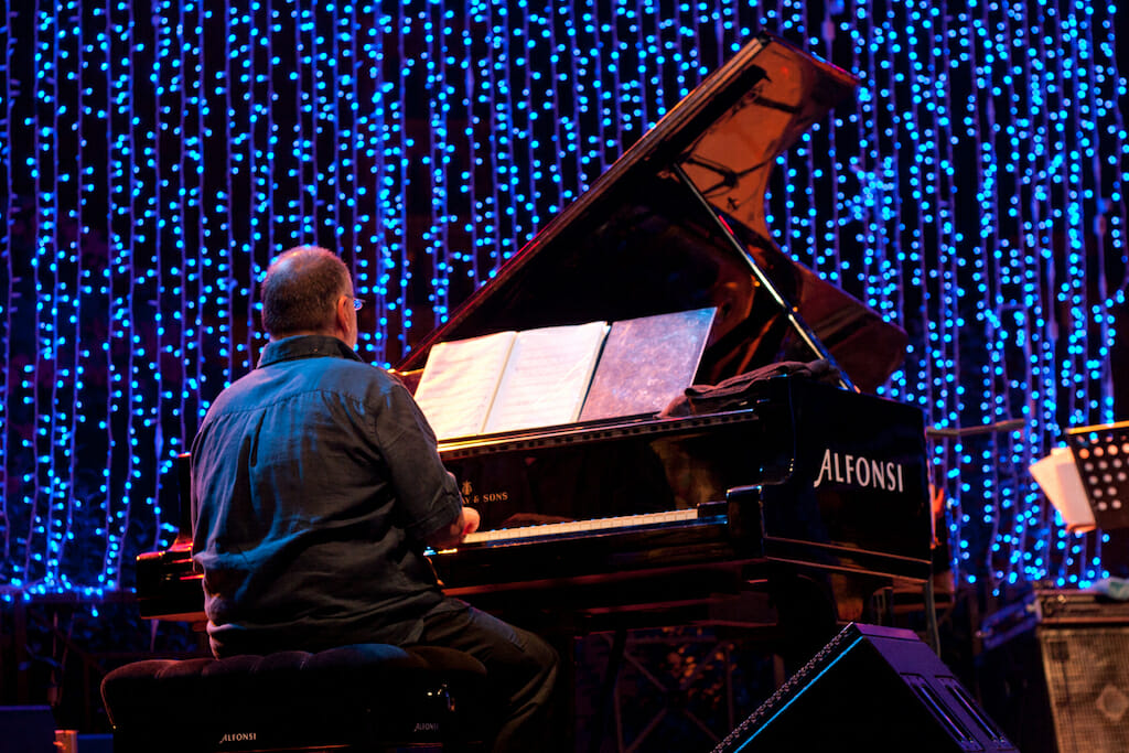 Man playing a piano at a jazz festival during August in Italy