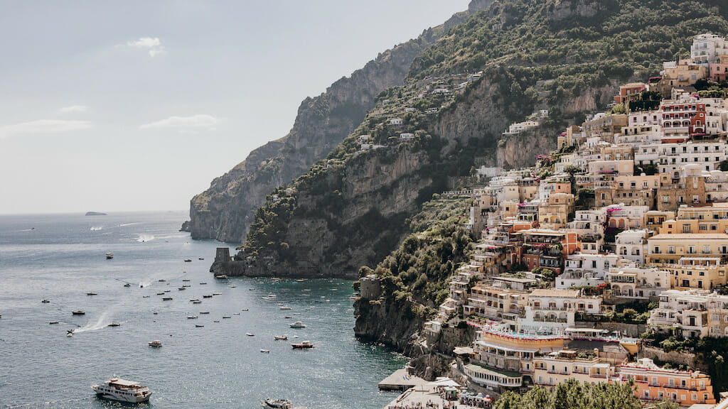 The coastline of the Amalfi coast, with boast and colorful buildings, as seen from Positano