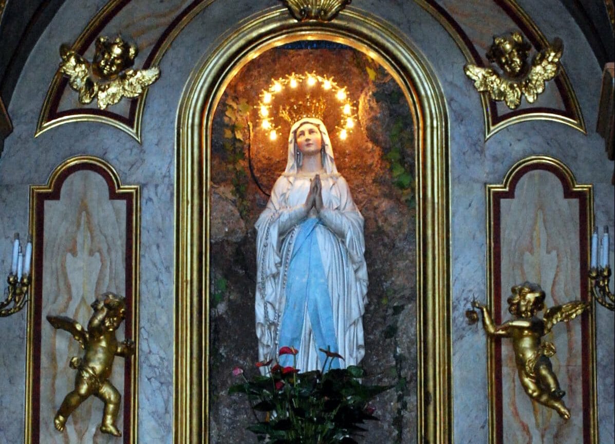 A statue of Mary praying inside of a church