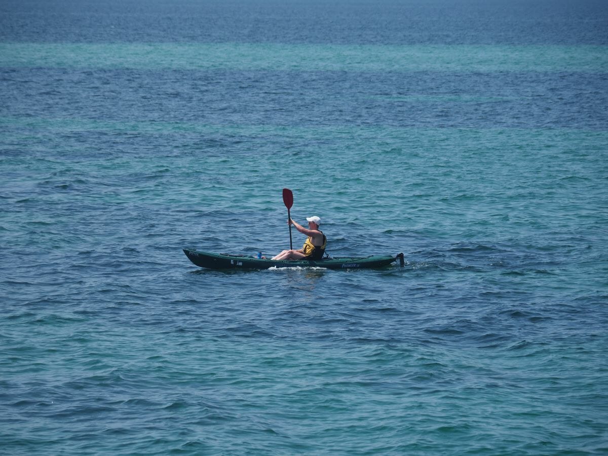 A man kayaking in the ocean