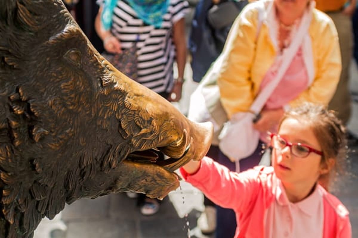 girl touching a wild boar statue