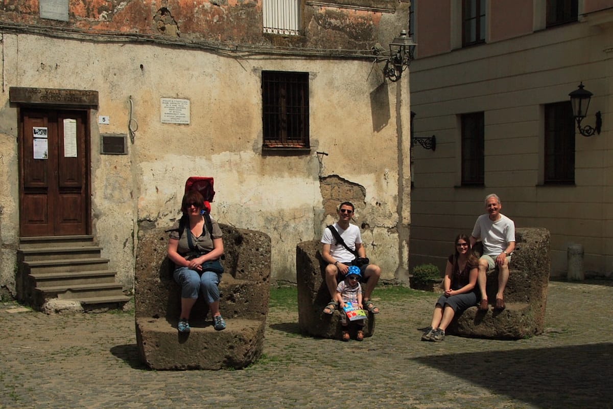 people sitting on stone chairs in Italy