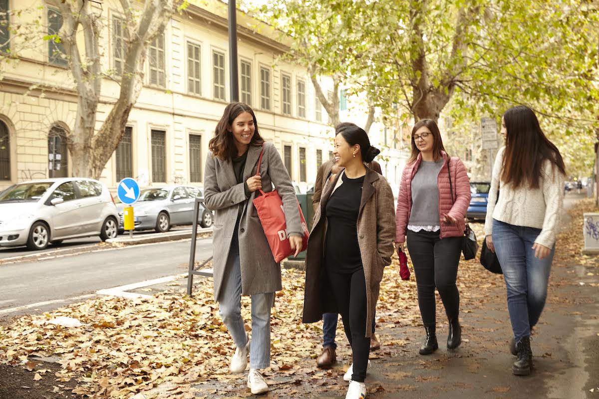 People laughing and smiling while walking down the street on a fall day