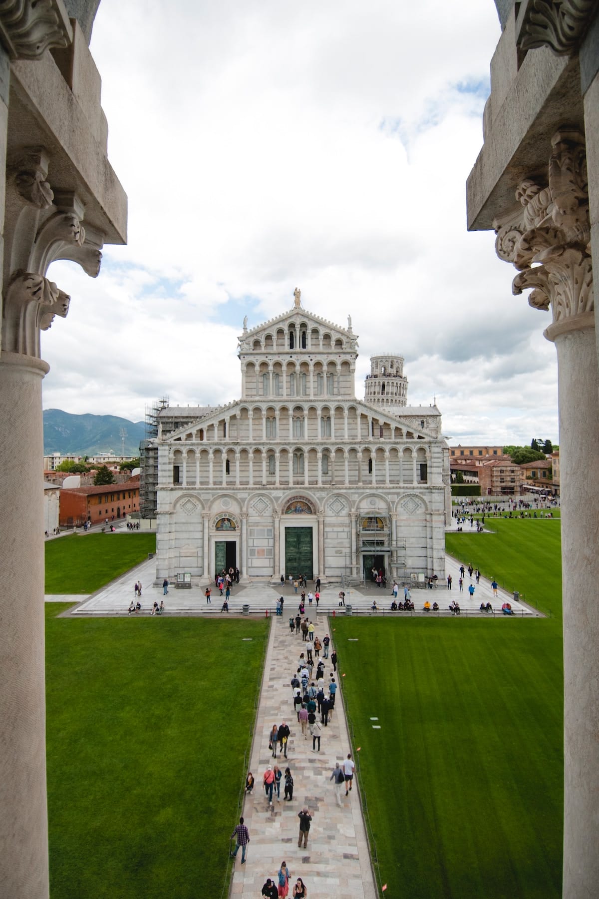 an aerial view of a building in Pisa, Italy with people walking nearby