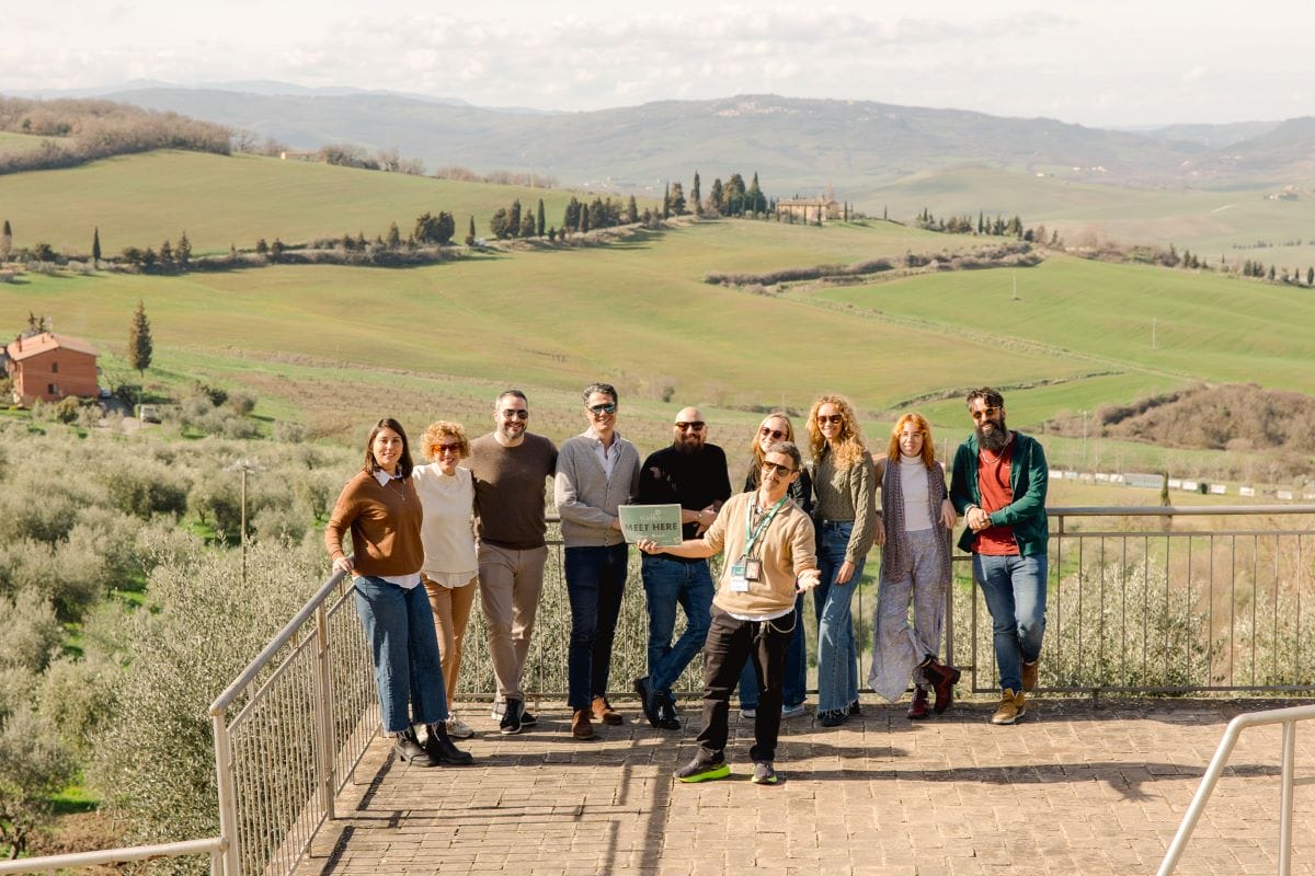 A group of people on a Tuscany Day Trip from Rome with green hillsides behind them.