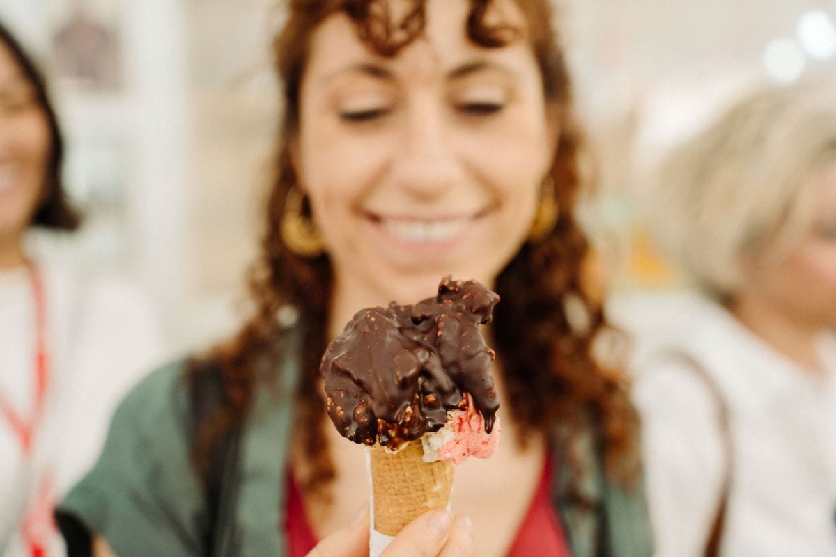 A woman smiling as she's about to enjoy a delicious gelato.