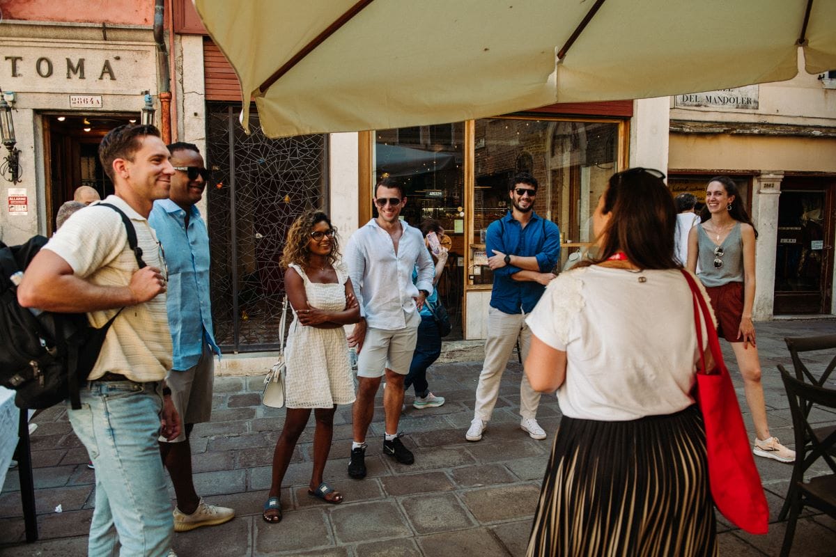 A group of people on the street listening to a tour guide.