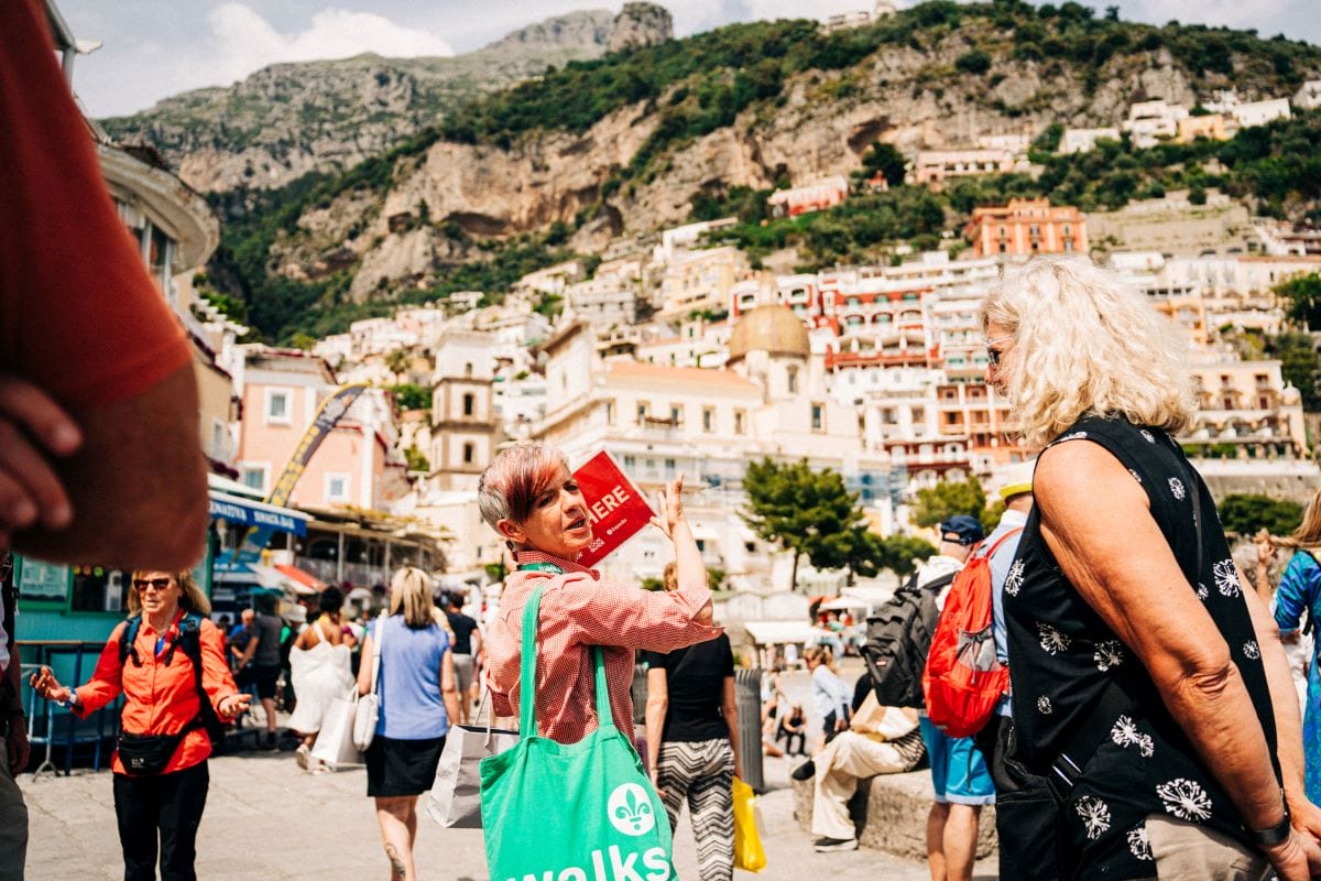 A tour guide speaking with a group of people as they explore the Amalfi Coast.