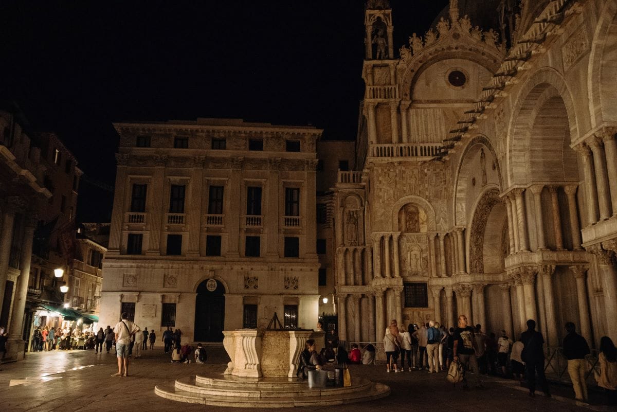 A group of people in Venice on a tour of St. Mark’s Basilica after dark .