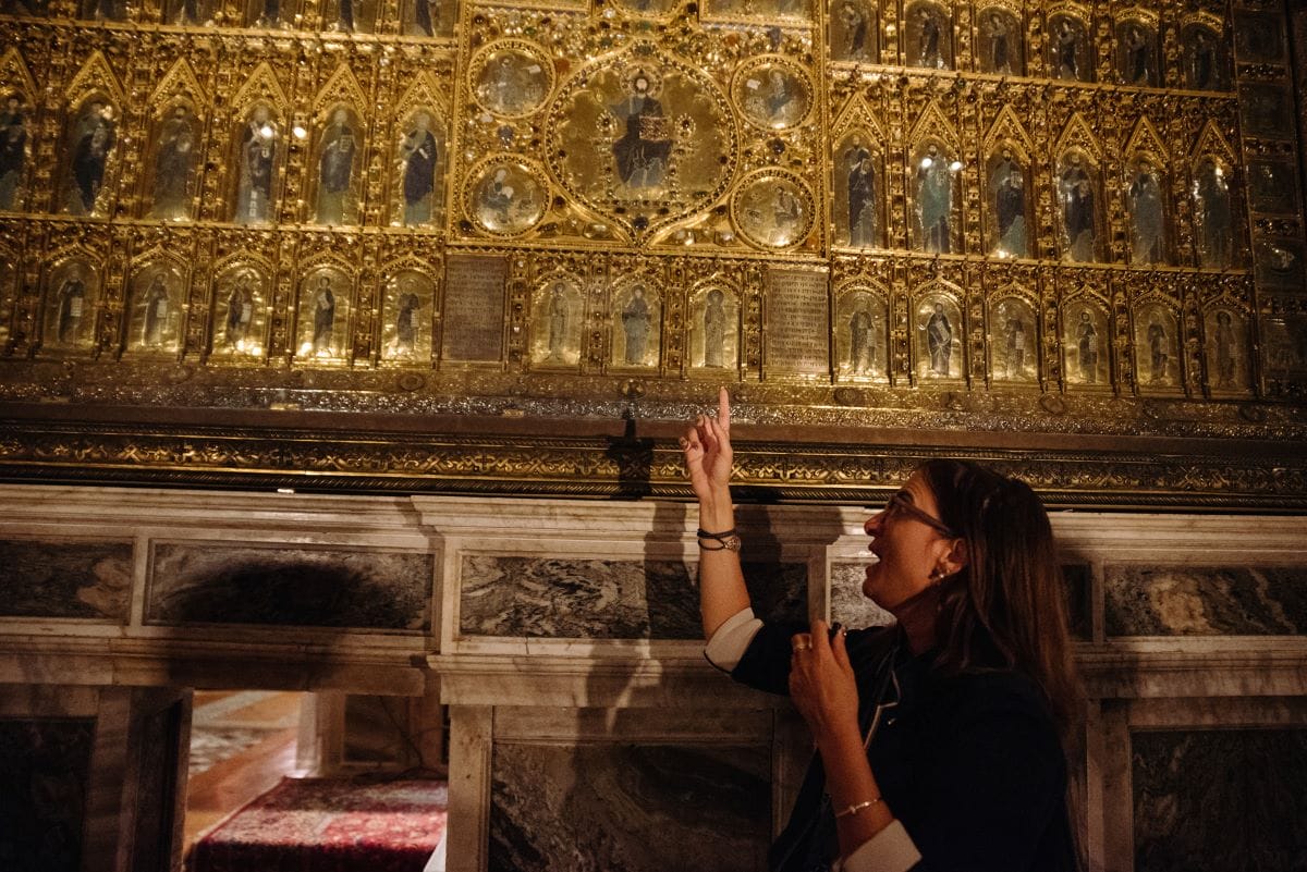 A tour guide explaining the Pala d'Oro Mosaic to people touring St. Mark’s Basilica.