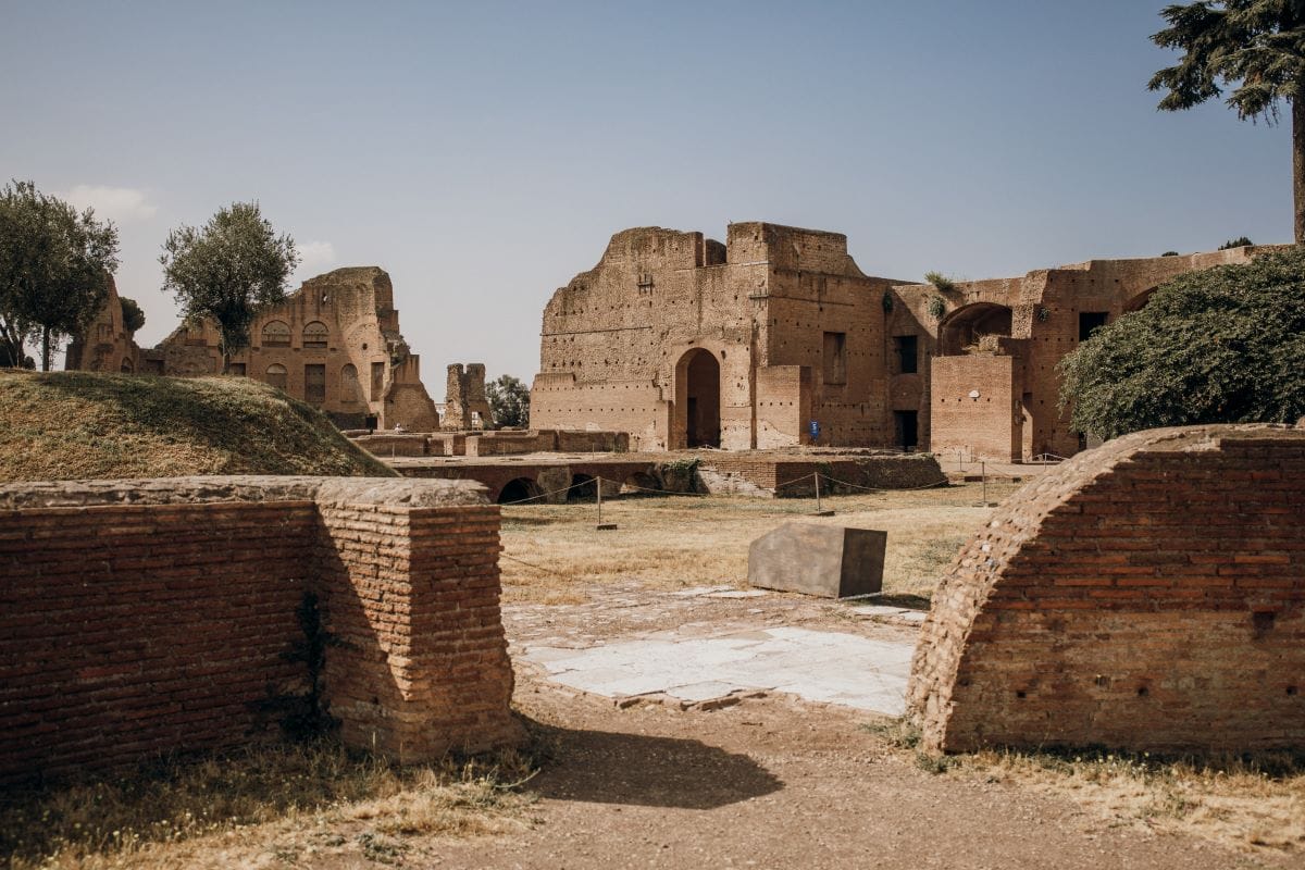Ancient Roman brick ruins that make up the Super Sites of Rome with arched doorways and weathered walls.