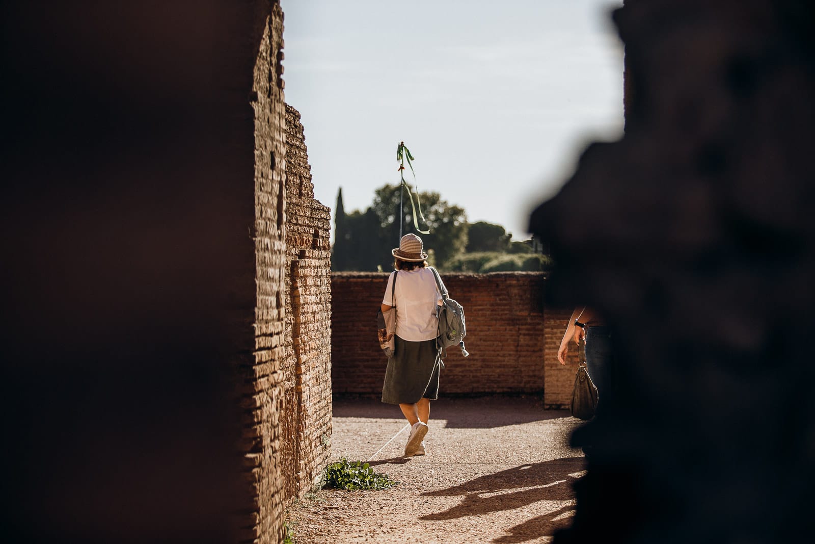 A person walking through a quiet corridor of the ruins at the Colosseum
