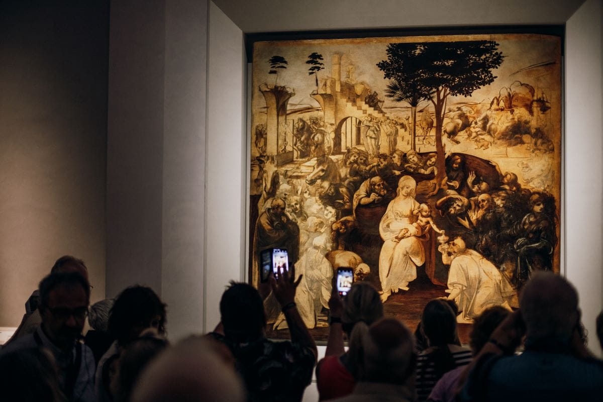 A group of people taking in a large piece of artwork in Florence.
