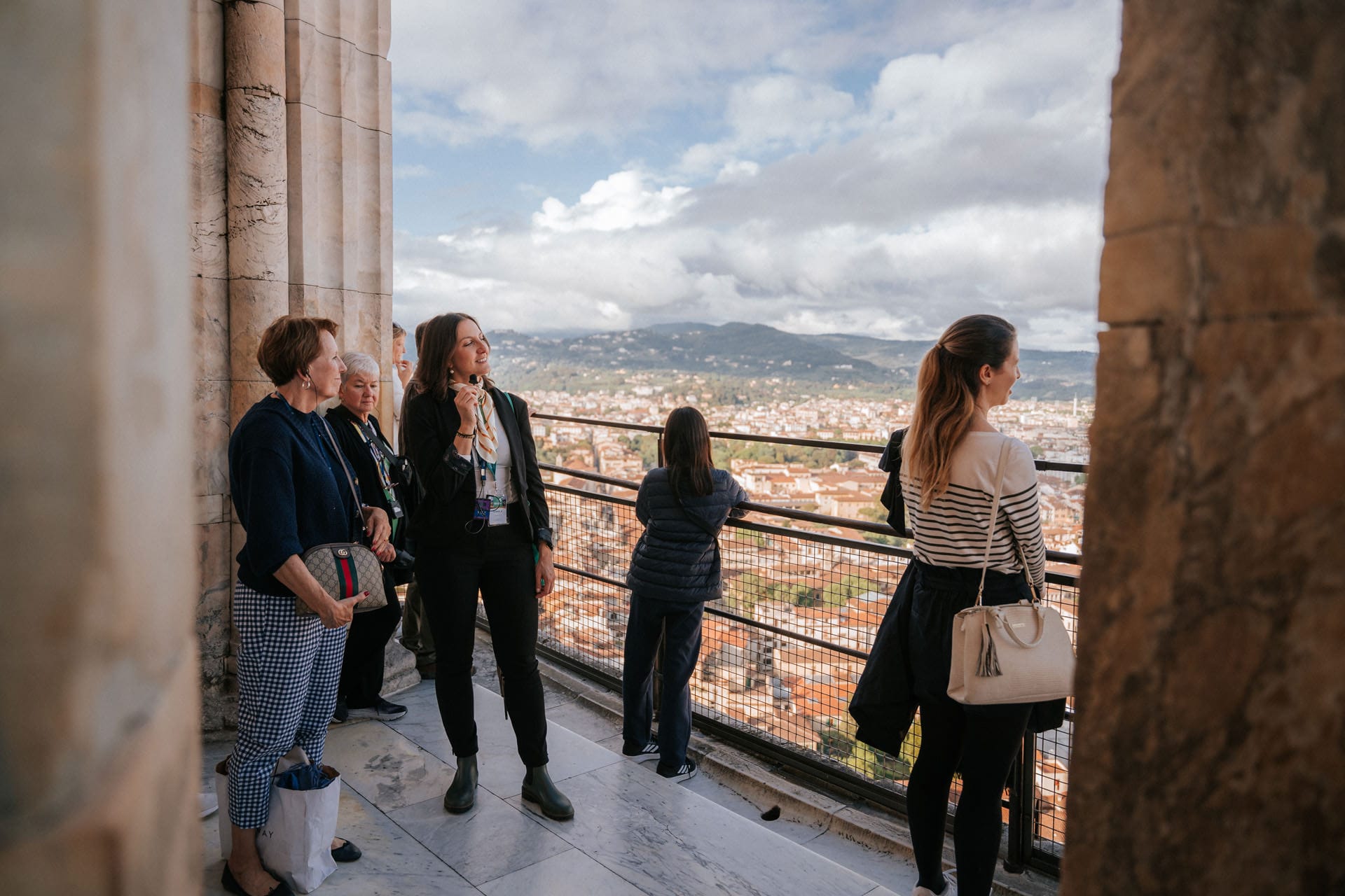 A group of tourists enjoys the breathtaking view of Florence’s terracotta rooftops and surrounding hills from the dome’s summit.