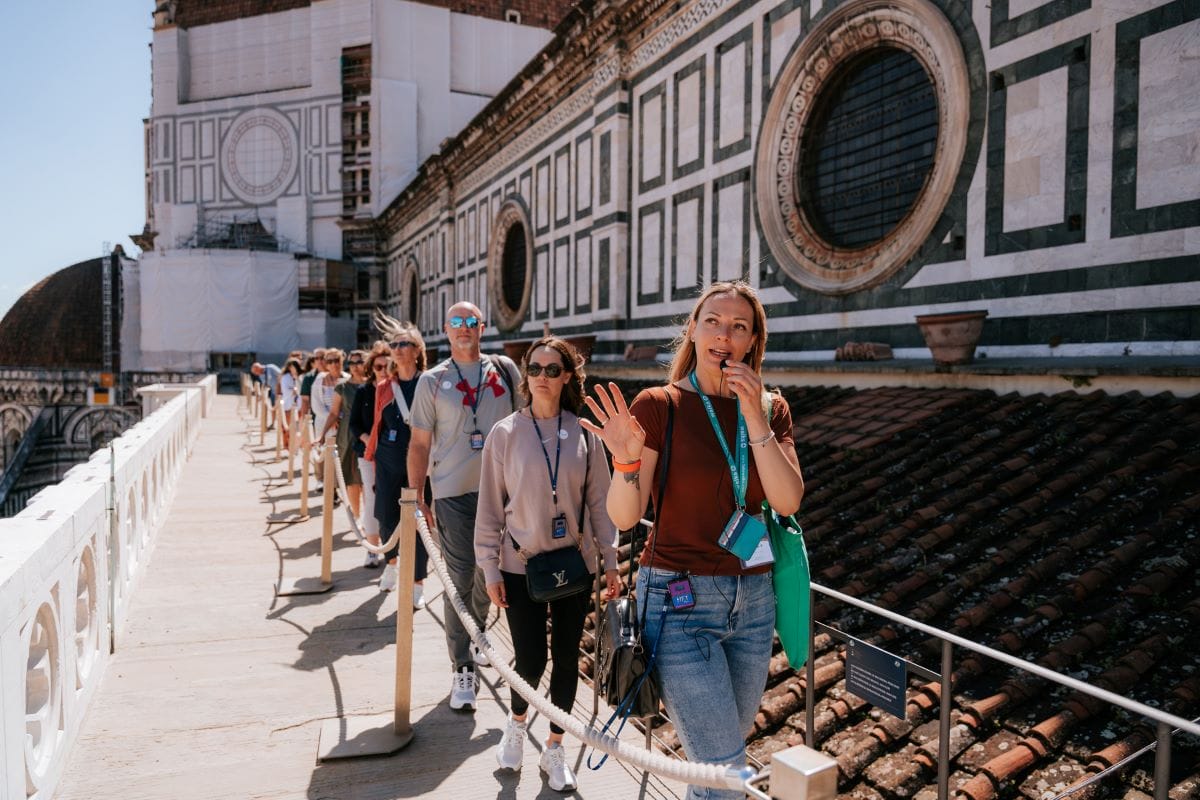 A group of people walking on the rooftops of Florence's famous landmark while on a tour of the Duomo.