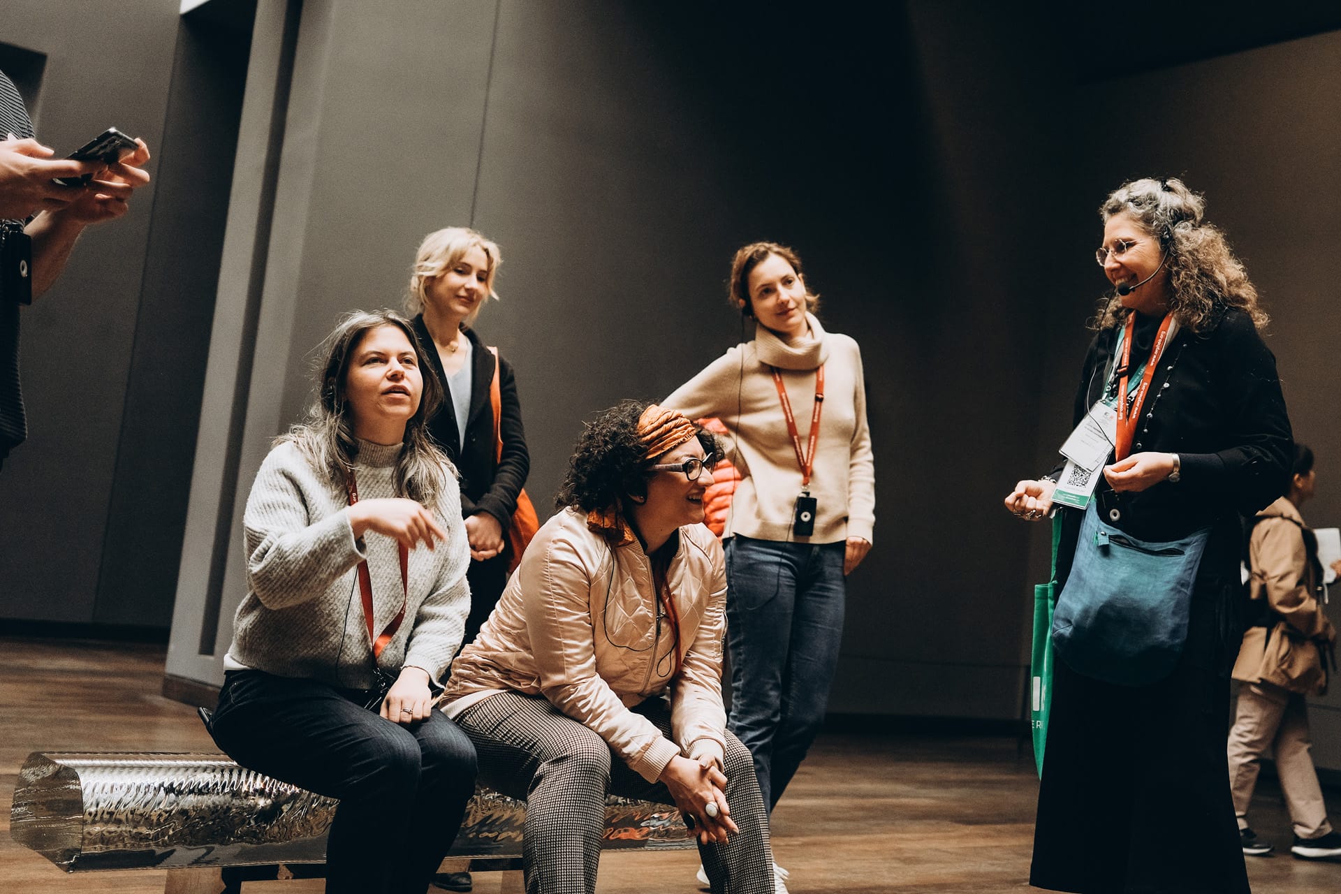 A small group of visitors sitting and engaging in a conversation during their guided tour of the Musée d'Orsay, one of the best impressionist museums in paris. 