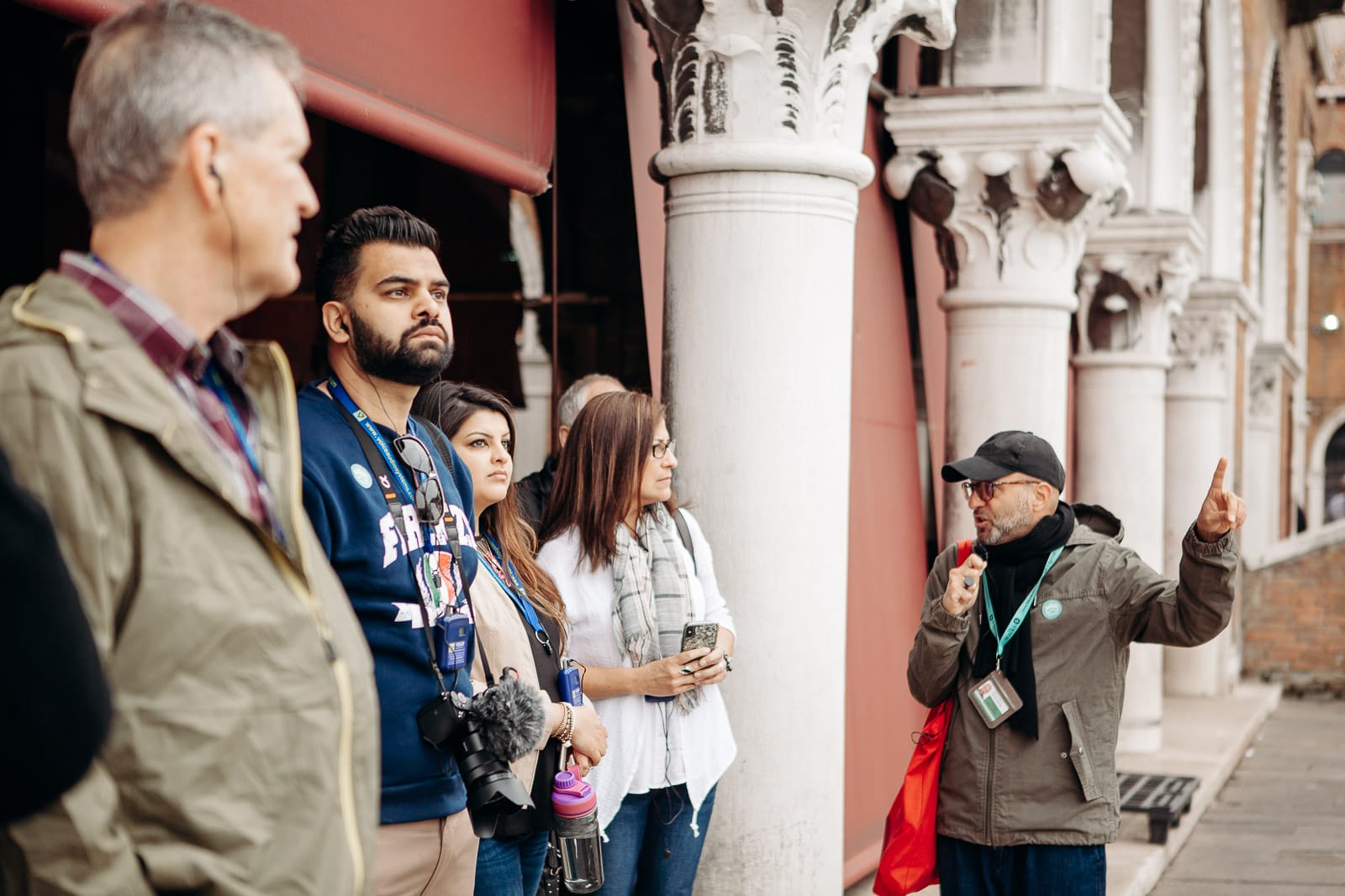 A tour guide explains the history of the architecture to a group of visitors in Milan
