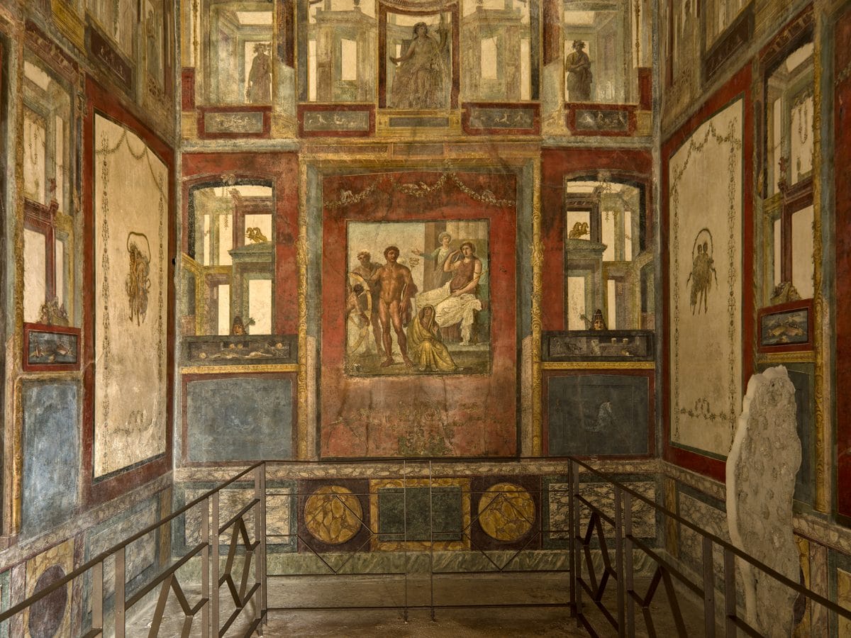 an interior wall with panels of art, from inside the house of the vettii in Pompeii