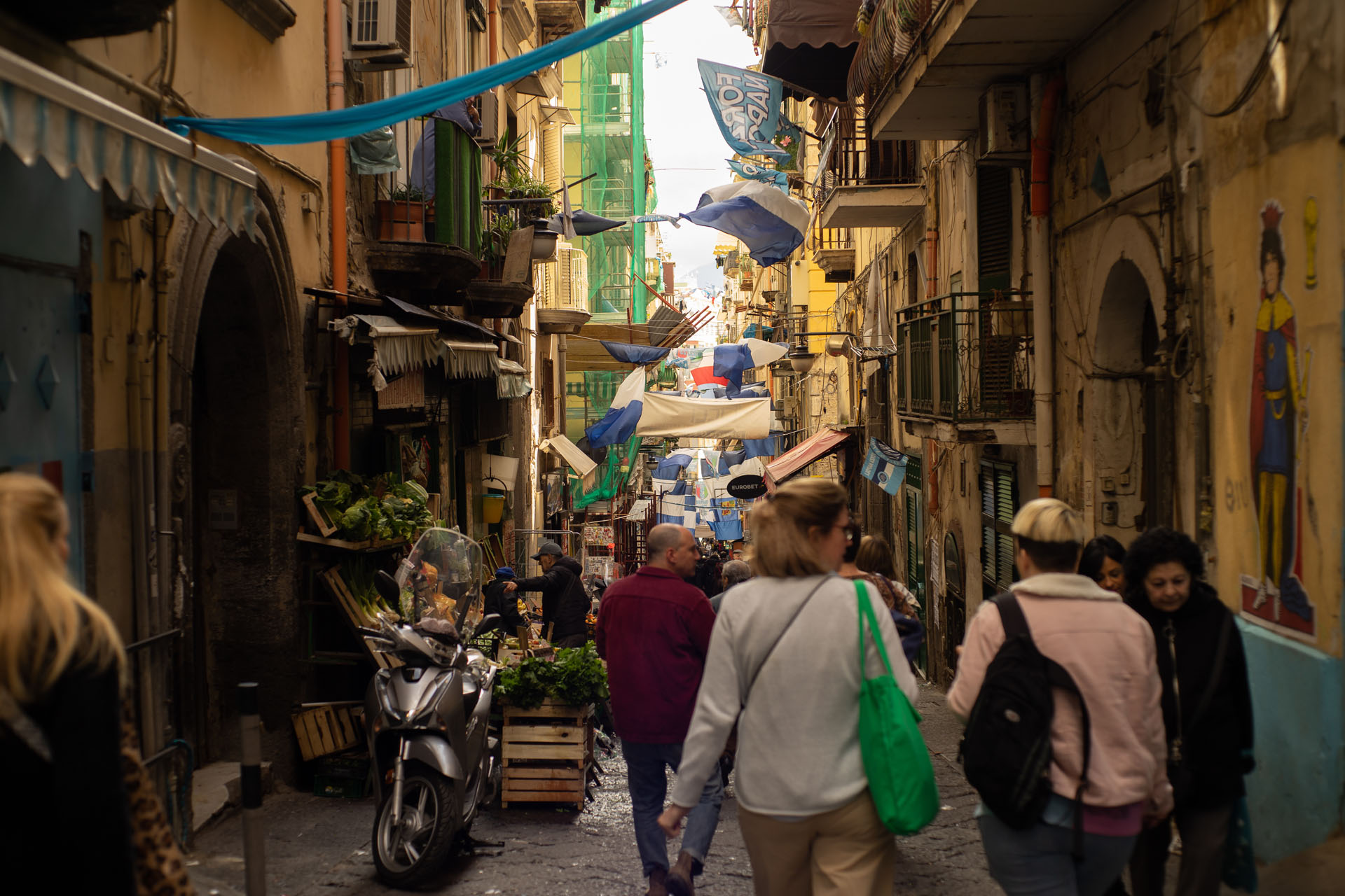 a group of visitors walking the streets of the historic centre of naples